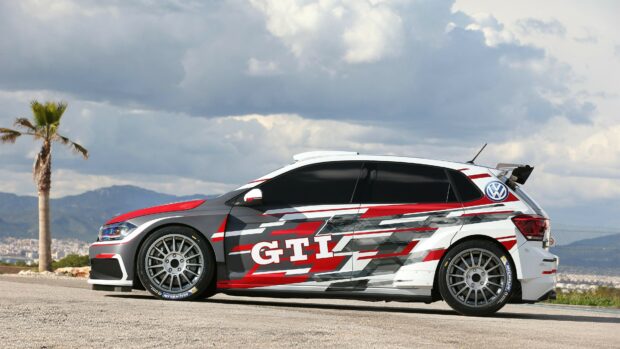 A Volkswagen GTI race car with red black and white design on a clear day