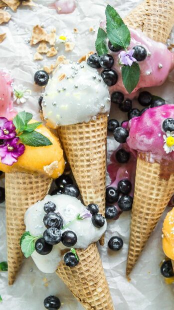 Colorful waffle cones with assorted ice cream and fresh blueberries decoration