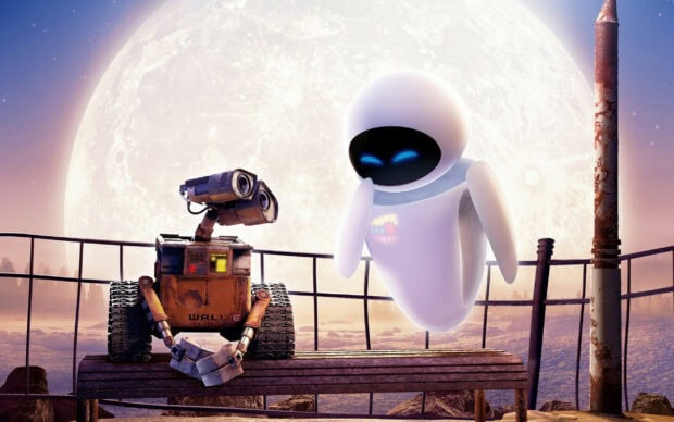 Robot character Walle and Eve sitting together under a large moon on a wooden bench