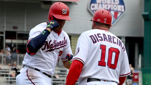 Washington Nationals player celebrating with coach on the field during a baseball game