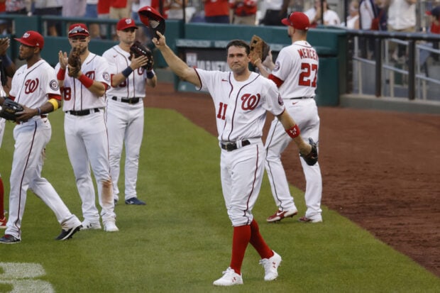 Washington Nationals players celebrating on the field after a game in their uniforms with red accents