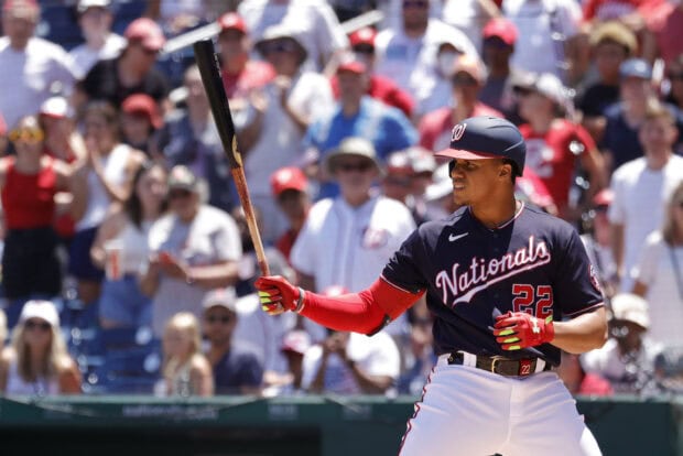 A Washington Nationals player preparing to bat in a baseball game with a crowd in the background