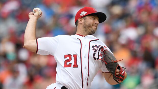 Washington Nationals player pitching during a baseball game in a packed stadium