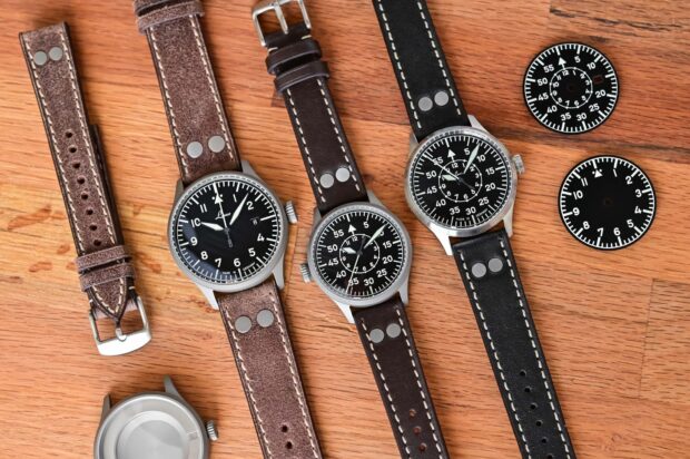Vintage watches with leather straps and detailed dials on wooden surface