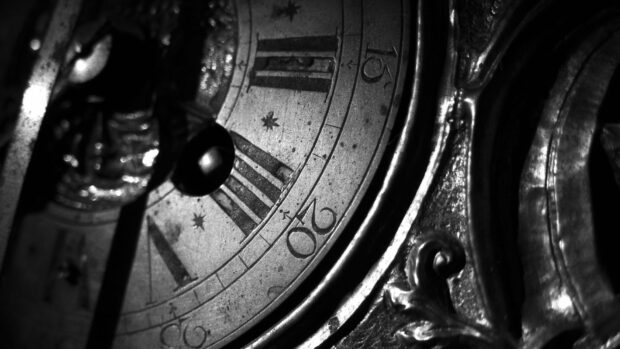 Close up of antique watch dial showing Roman numerals and detailed metalwork design