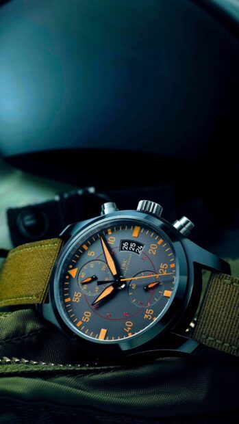 Military style watch with orange accents and green fabric strap on tactical gear