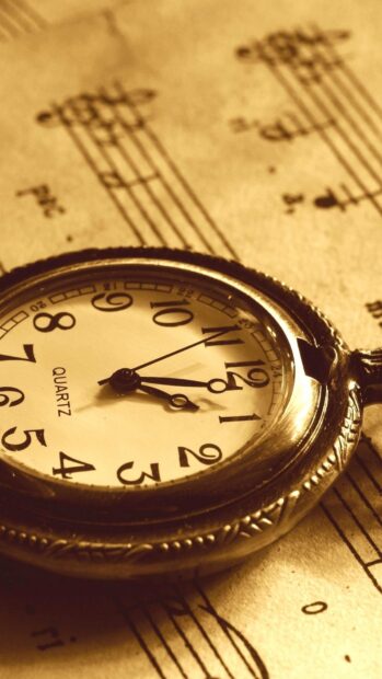 Vintage pocket watch on sheet music with old style design