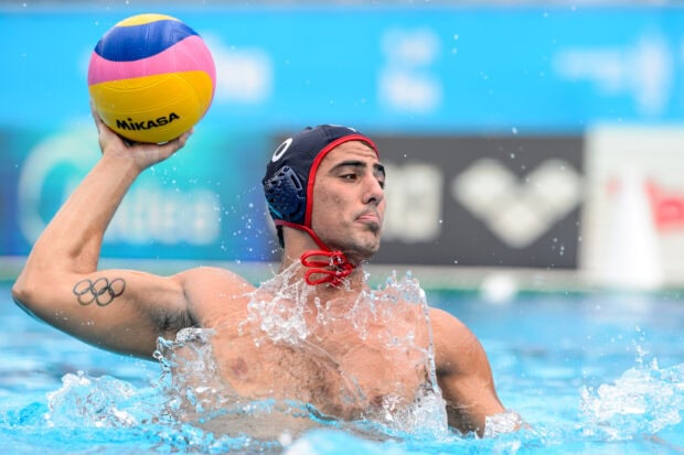 Male athlete with water polo ball preparing to throw in a water polo match