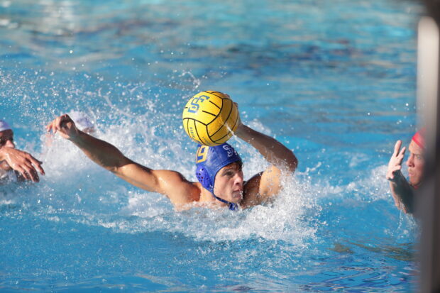 Water polo player preparing to throw the ball during an intense match in a swimming pool