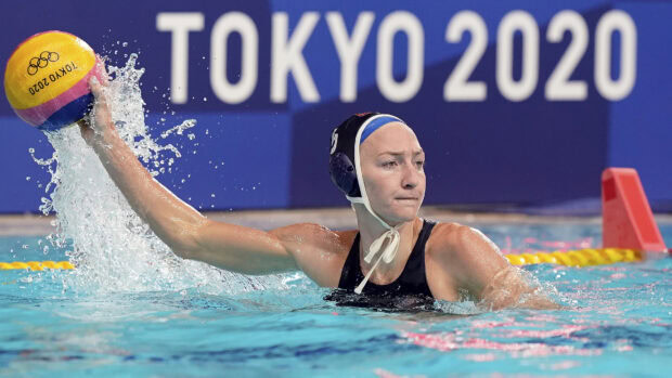Female athlete playing water polo with ball in pool during Tokyo 2020