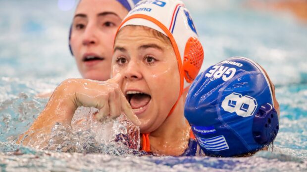 Female water polo player making a hand gesture during a game in the pool
