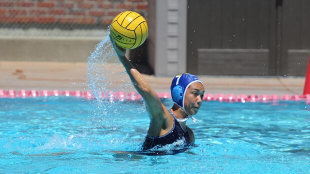 Water polo player preparing to throw the ball in a swimming pool during a match