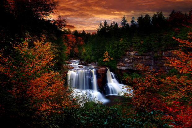 A scenic waterfall surrounded by vibrant autumn foliage in West Virginia