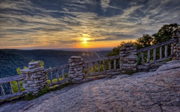 West Virginia landscape with rocky railing overlooking forest at sunset