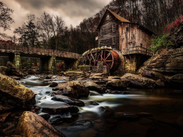 Historic West Virginia mill along the rocky river surrounded by autumn woods