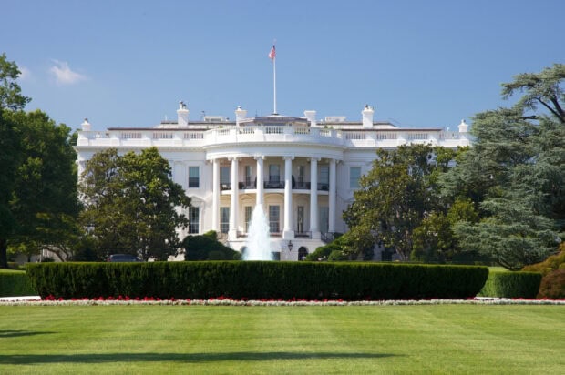 White House seen with greenery and fountain on a clear sunny day