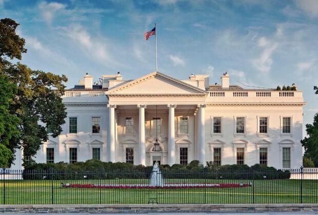 The White House building with an American flag under a blue sky