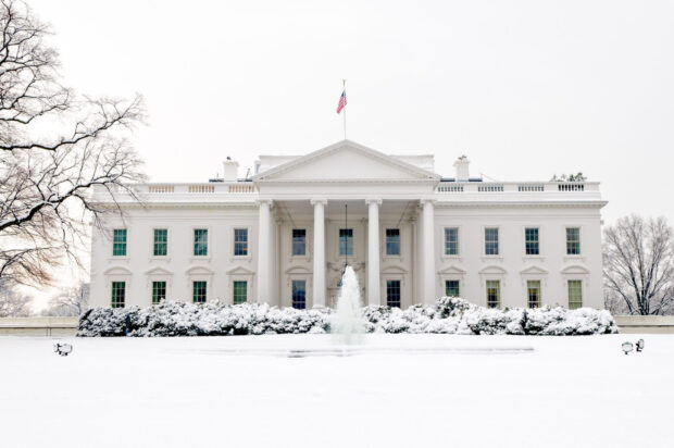 The White House covered in snow with a fountain in front during winter