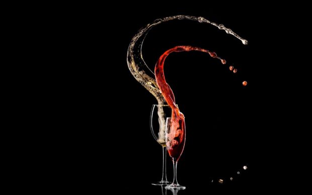 Red and white wineglass splash captured in motion against black background