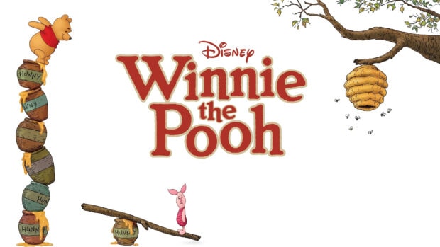 Winnie The Pooh character balancing on honey pots with Piglet on a seesaw and a beehive hanging from a tree branch