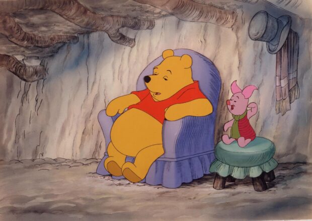 Winnie The Pooh resting on a chair inside his house with Piglet nearby