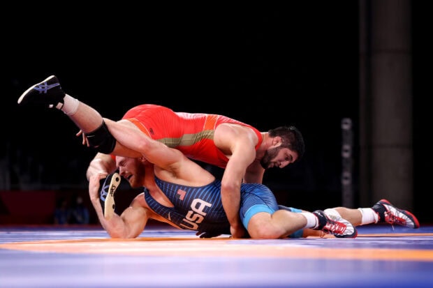 A wrestling match showing intense grappling between two athletes in wrestling gear