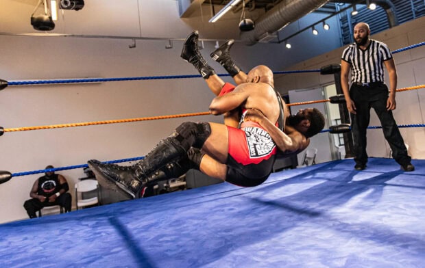 Two wrestlers performing a high impact move inside the wrestling ring