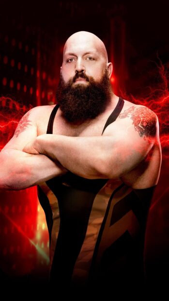 Strong wrestler with a long beard and tattooed arms posing with crossed arms in a wrestling outfit