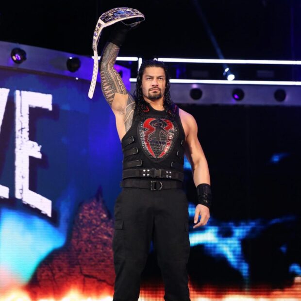 Wrestling athlete raising championship belt in wrestling ring with intense expression