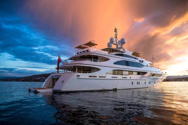 Luxury yacht on calm sea during colorful sunset sky