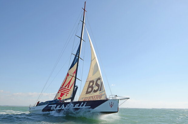 A Maserati yacht sailing on the sea under a clear blue sky