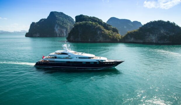Luxury yacht cruising near lush tropical islands on clear blue water