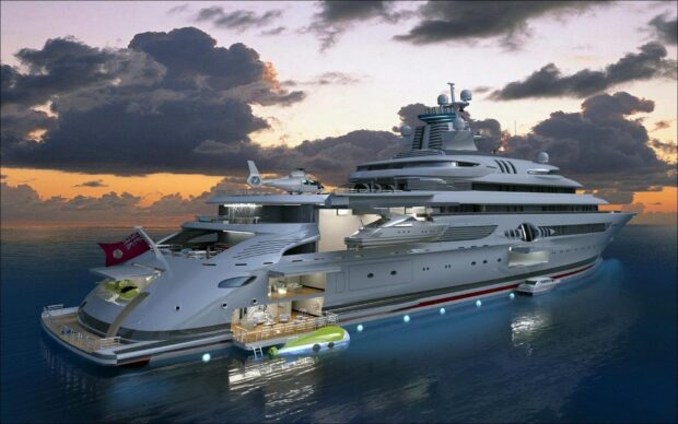Luxury yacht with helicopter and tender docked at sunset