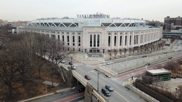 The exterior view of Yankee Stadium with city roads and leafless trees in winter