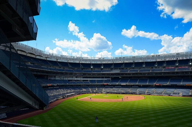 The Yankee Stadium field under bright blue sky during a baseball game