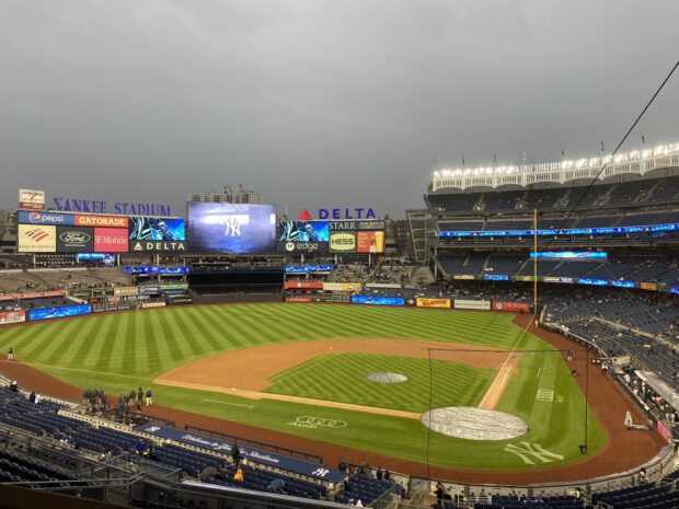 A wide view of Yankee Stadium showcasing the baseball field and seating under a cloudy sky