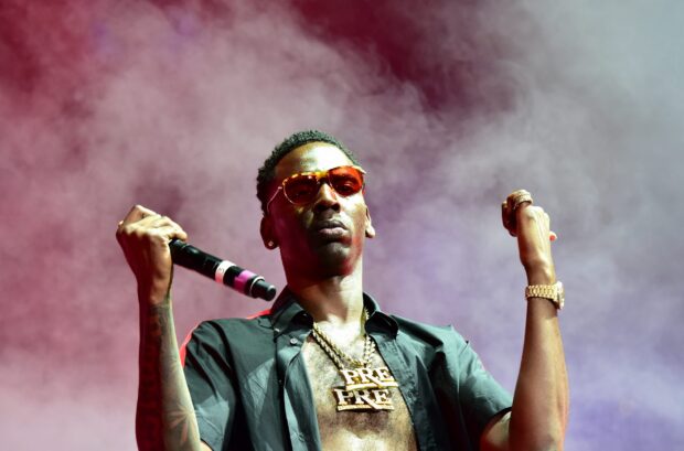 Young Dolph musician wearing sunglasses and chains performing on stage