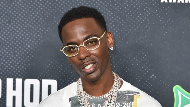Young Dolph wearing diamond glasses and chains at a hip hop event