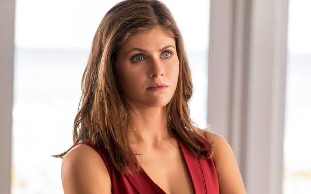 Alexandra Daddario looking thoughtful wearing a red dress indoors with natural light