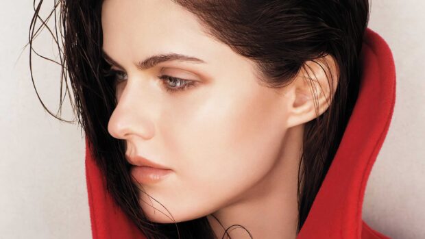 Close up of Alexandra Daddario wearing a red hoodie with wet hair and natural makeup