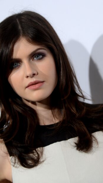 Close up portrait of Alexandra Daddario with dark hair and blue eyes looking at the camera