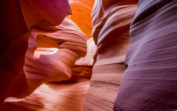 Smooth rock formations in Antelope Canyon with vibrant orange and purple hues