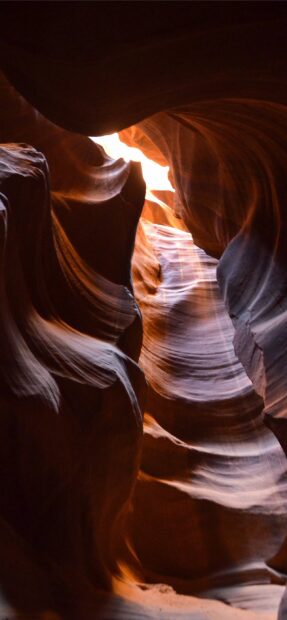 Curved rock formations in Antelope Canyon illuminated by natural light beams