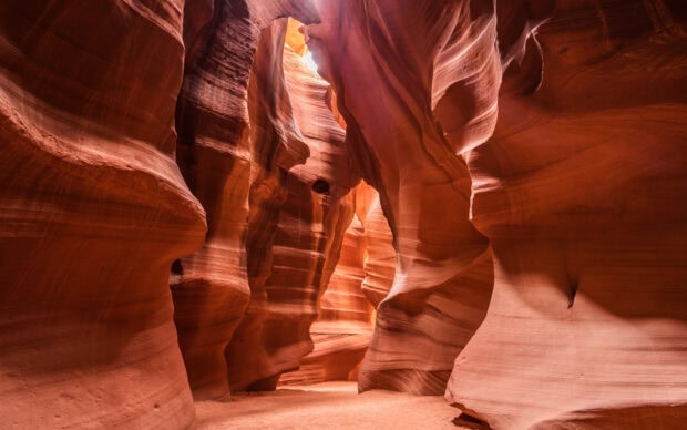 Narrow rock formations of Antelope Canyon with warm orange hues and sunlight streaming through