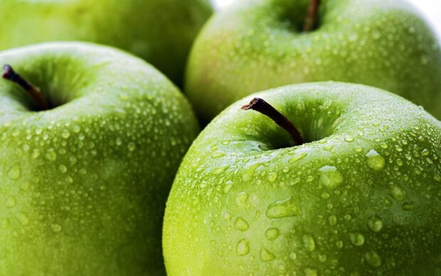 Fresh green apples covered with water droplets in close up view