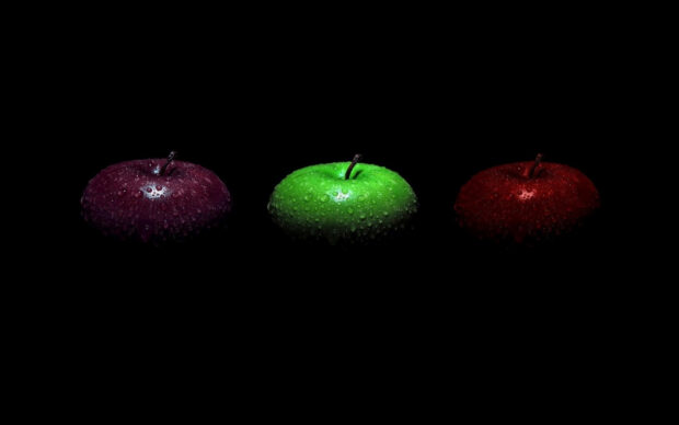 Three fresh apples with water droplets in green red and purple colors