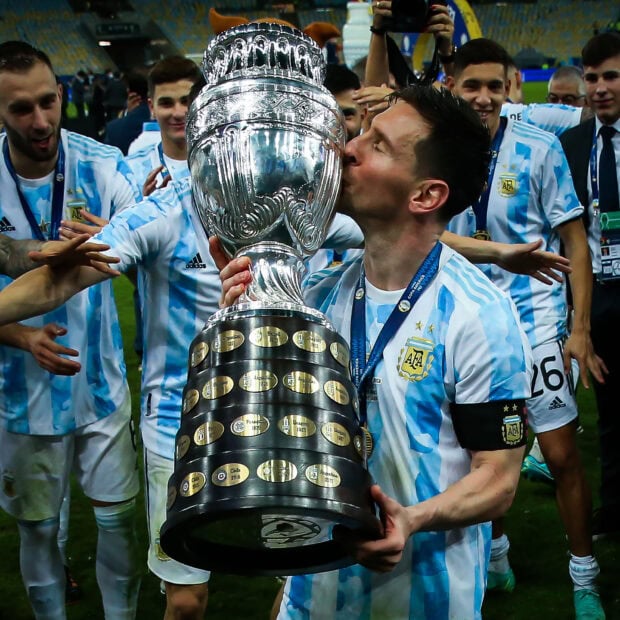 Argentina football player celebrating with trophy after winning championship