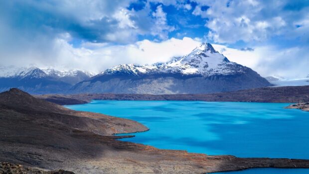 Snow capped mountains and blue lake in Argentina scenic landscape with clear sky