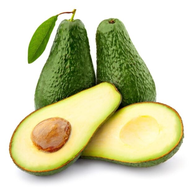 Two whole avocados with one cut open showing seed and creamy flesh