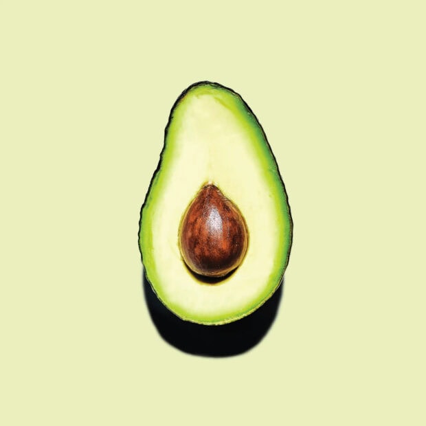 Fresh avocado cut with seed on light background
